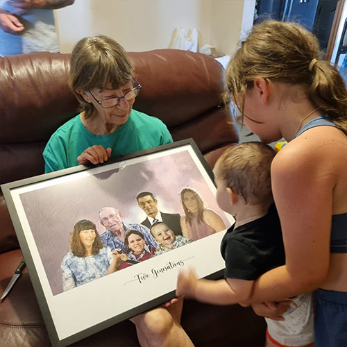 A grandmother holding a framed family portrait, with her grandchildren beside her