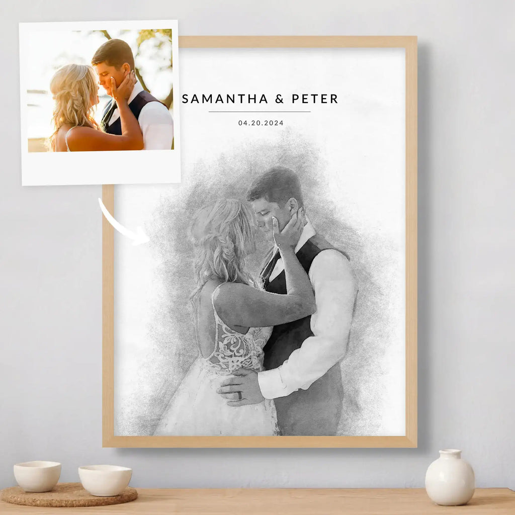 Sketch-style portrait of a couple embracing, in a light oak frame, beside its reference photo, with names and a date above