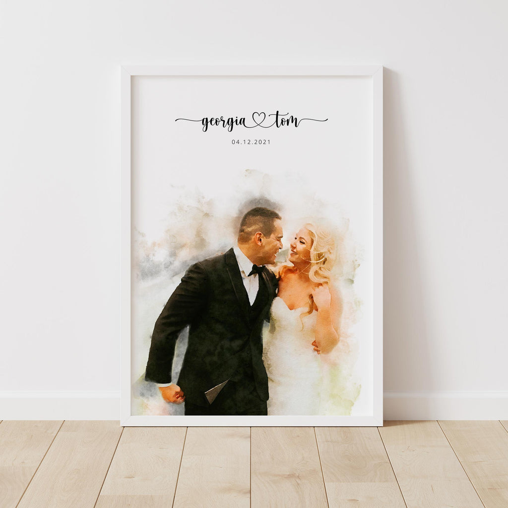 Watercolor-style portrait of a laughing couple, in a white frame on a wooden floor, their names and a date above